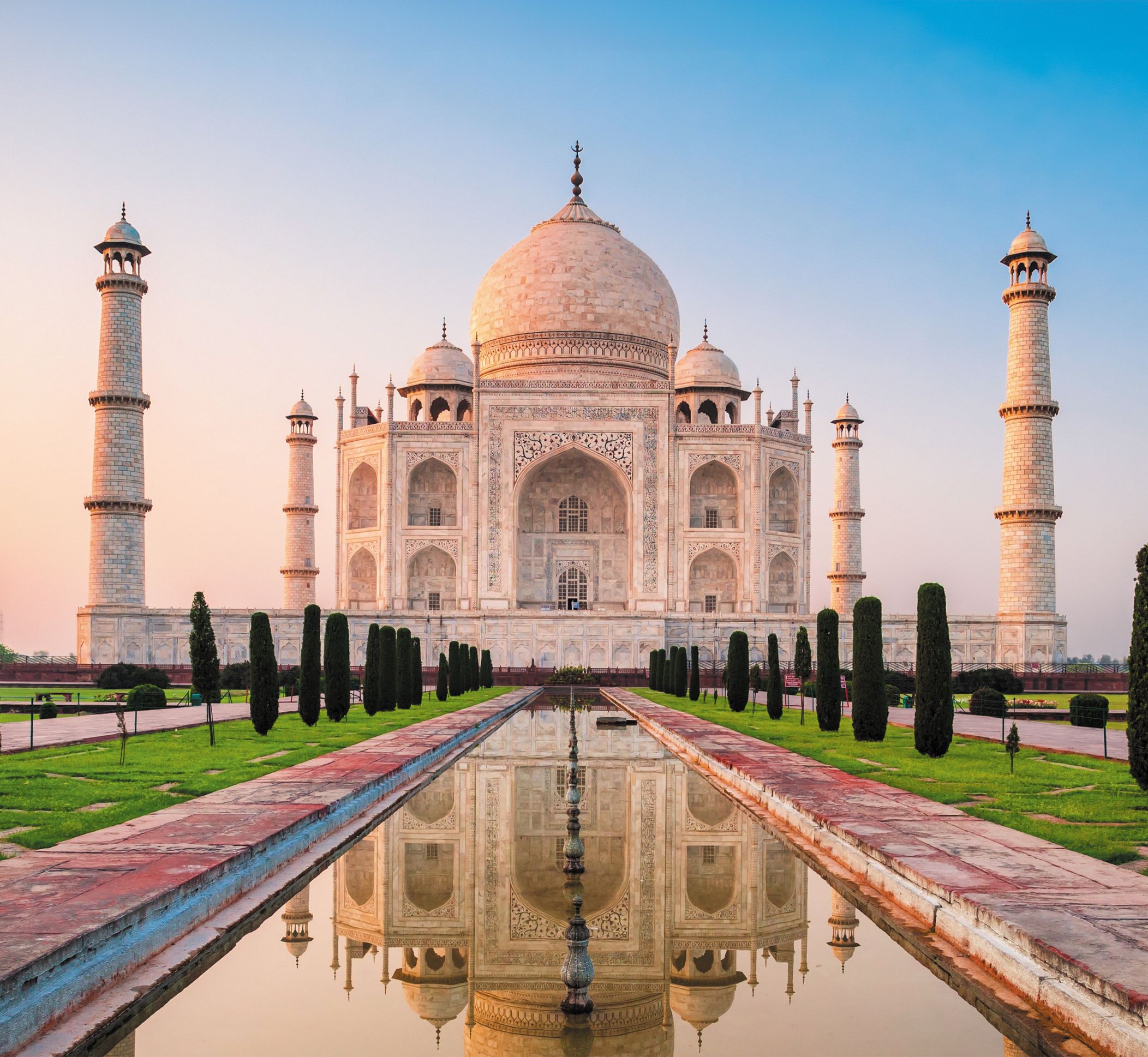 Taj Mahal's main elevation: a grand masterpiece of Mughal architecture, adorned with intricate calligraphic inscriptions, symmetrical design, and mesmerizing interplay of light and shadow, inspiring visitors worldwide.